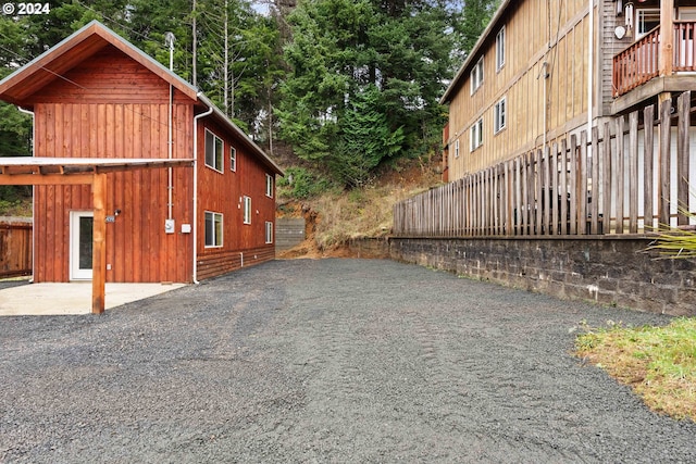 view of home's exterior featuring a patio, board and batten siding, and fence