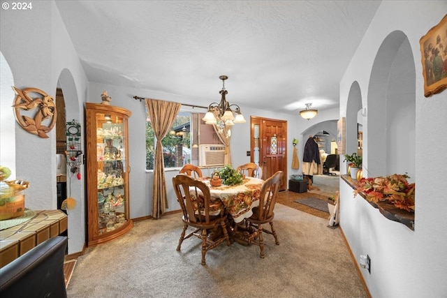 carpeted dining area with cooling unit, a textured ceiling, and an inviting chandelier