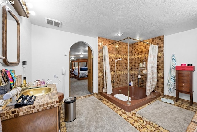 bathroom featuring a textured ceiling, vanity, and walk in shower