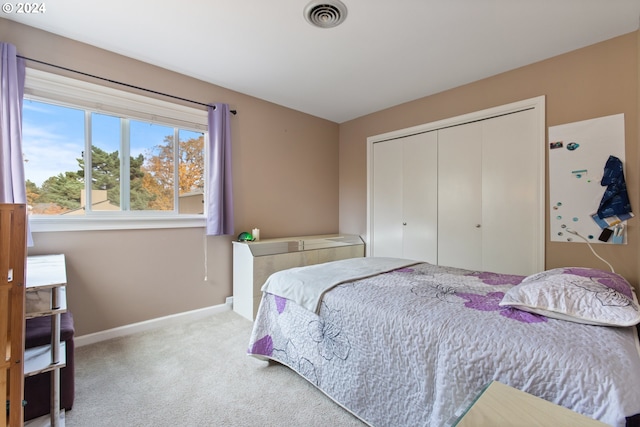 bedroom with light carpet and a closet