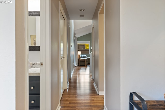 hall featuring dark hardwood / wood-style floors and lofted ceiling