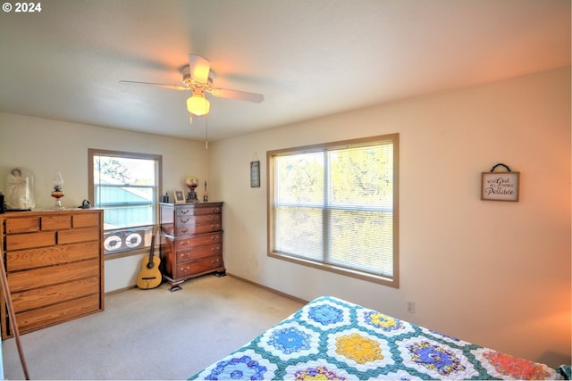 bedroom with ceiling fan and light carpet