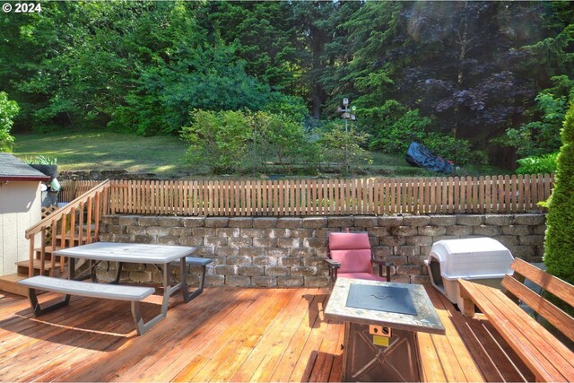 wooden deck with grilling area and a fire pit