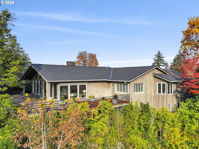 rear view of property with a wooden deck and a sunroom