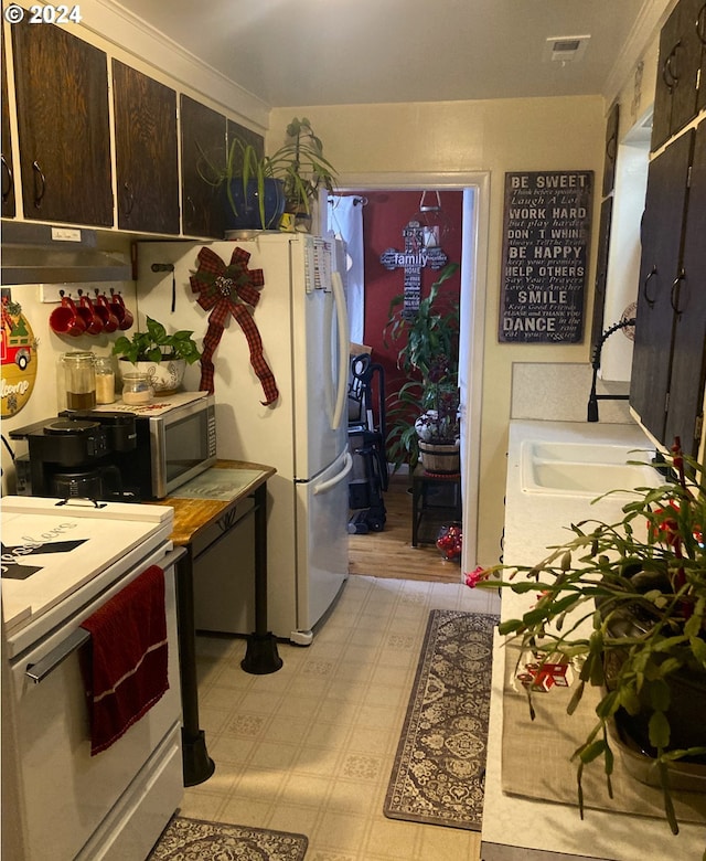 kitchen with stove, sink, and dark brown cabinetry