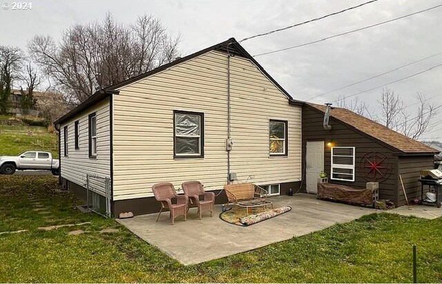 rear view of property featuring a yard and a patio