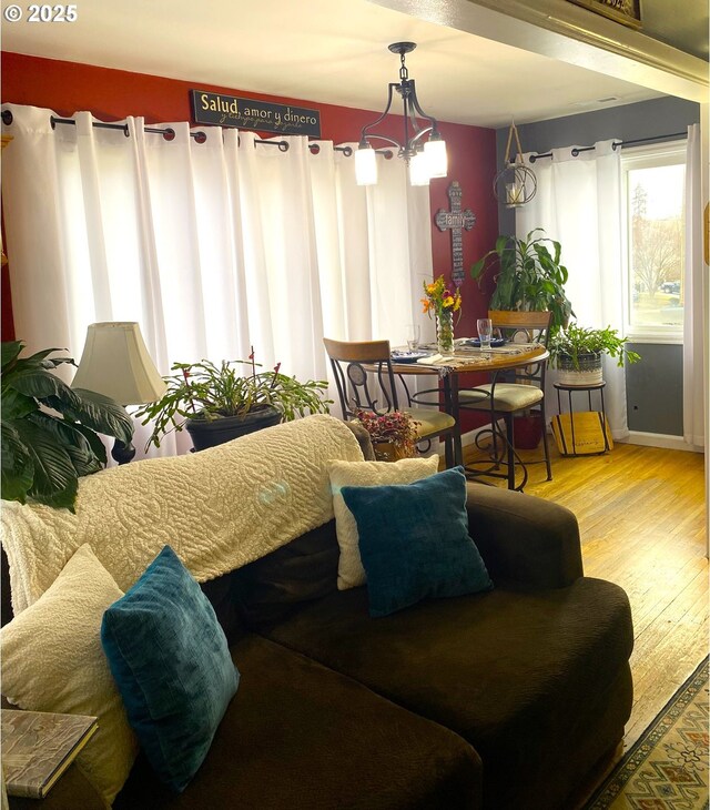 living room with a chandelier and light wood-type flooring