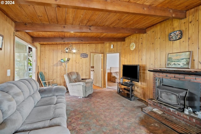 carpeted living room with wood ceiling, beamed ceiling, wooden walls, and a wood stove