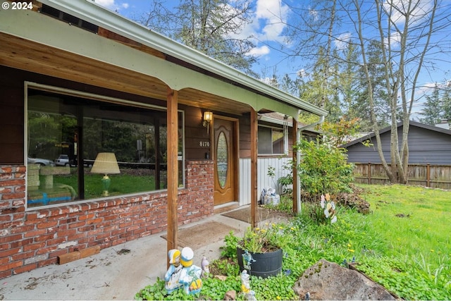 view of exterior entry with a lawn