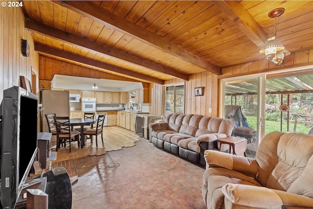 living room featuring a notable chandelier, wood walls, wood ceiling, and lofted ceiling with beams