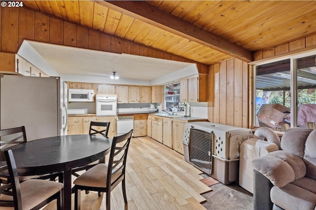 dining room with light hardwood / wood-style floors, sink, beamed ceiling, wooden walls, and wood ceiling