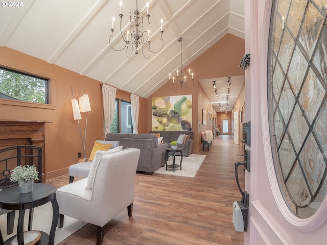 living room featuring high vaulted ceiling, hardwood / wood-style flooring, and an inviting chandelier