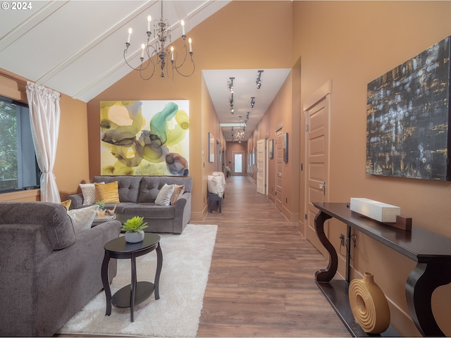 living room with light hardwood / wood-style flooring, a chandelier, and vaulted ceiling