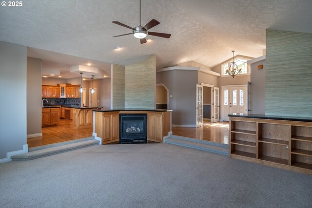 living room with ceiling fan, a textured ceiling, lofted ceiling, and light colored carpet