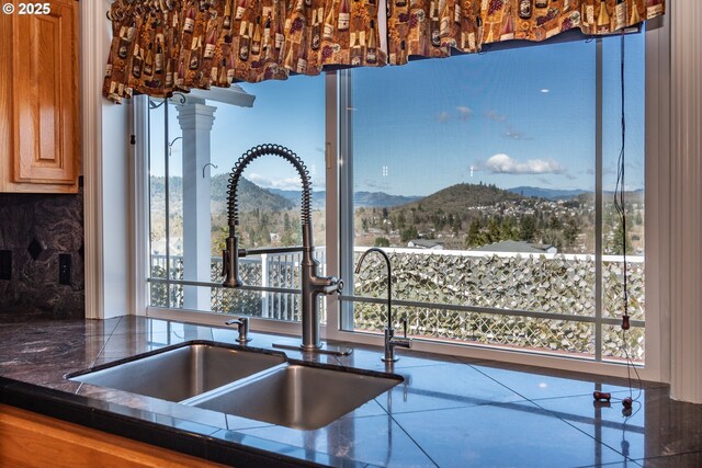 kitchen with island range hood, light hardwood / wood-style floors, stainless steel appliances, a mountain view, and a kitchen island with sink