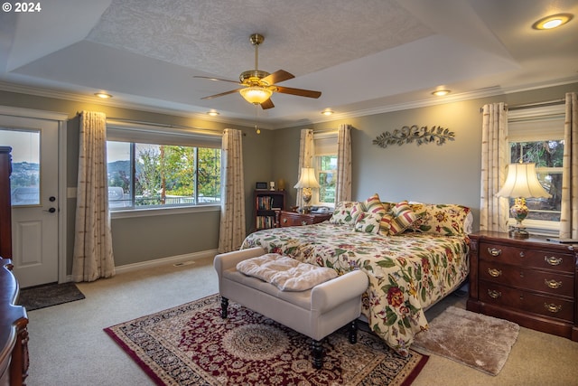 carpeted bedroom featuring crown molding, a textured ceiling, ceiling fan, and a raised ceiling