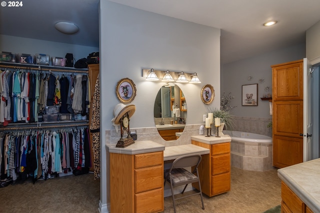 bathroom featuring vanity and a relaxing tiled tub