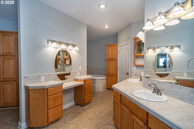 bathroom with a garden tub, recessed lighting, double vanity, and a sink