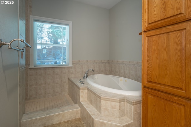 bathroom featuring a bath and tiled shower