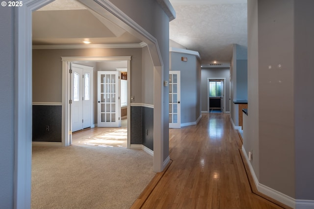 hall with carpet, baseboards, and ornamental molding