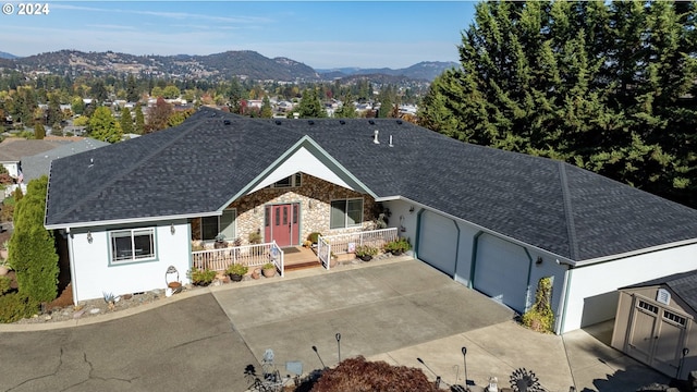 ranch-style home with a mountain view, covered porch, and a garage