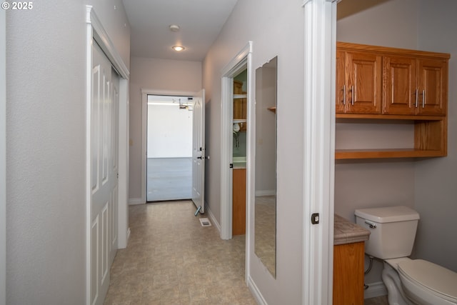 hall featuring baseboards and light floors