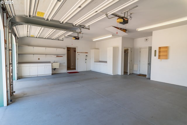 garage with a garage door opener and a sink