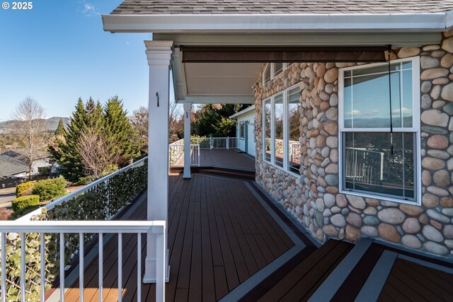 wooden terrace with a mountain view and ceiling fan