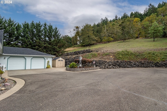 exterior space with aphalt driveway and a shed