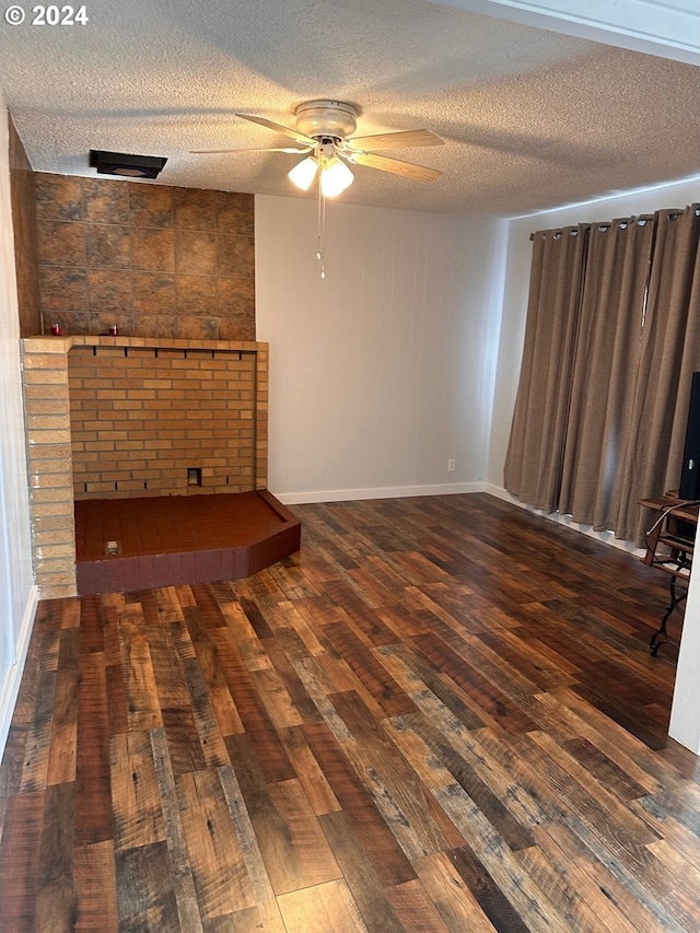 1106 N Myrtle Rd, Myrtle Creek, OR 97457 - unfurnished living room with a ceiling fan, wood-type flooring, a textured ceiling, and a large fireplace