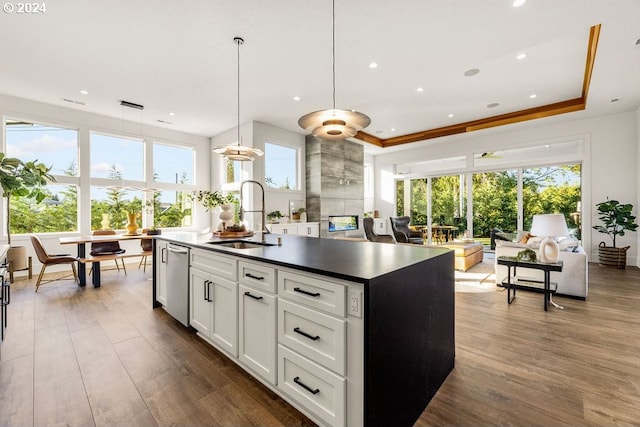 kitchen with dark hardwood / wood-style floors, an island with sink, decorative light fixtures, and sink