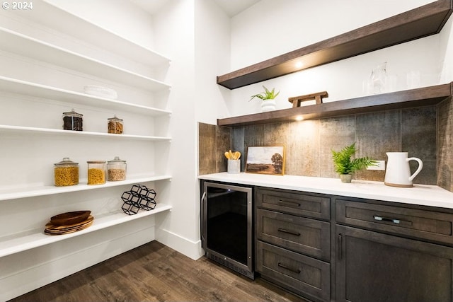 interior space featuring beverage cooler, dark brown cabinets, and dark hardwood / wood-style flooring