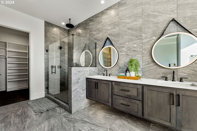 bathroom featuring tile walls, double vanity, tile floors, and a shower with shower door