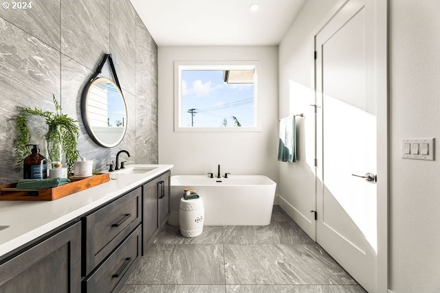 bathroom with tile flooring, a bathing tub, and vanity