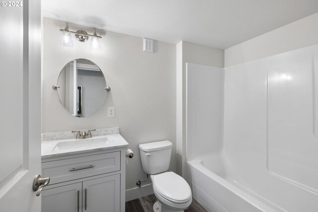 full bathroom with hardwood / wood-style floors, vanity, bathing tub / shower combination, and toilet