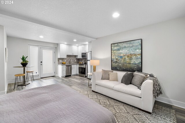 living room with light hardwood / wood-style floors and a textured ceiling