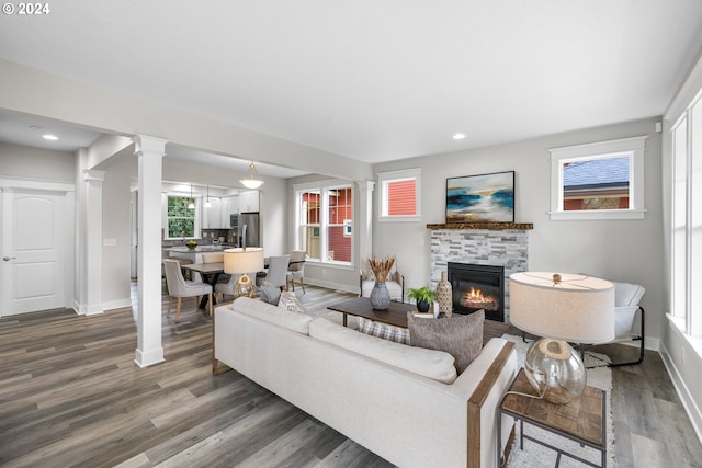 living room with decorative columns and dark wood-type flooring