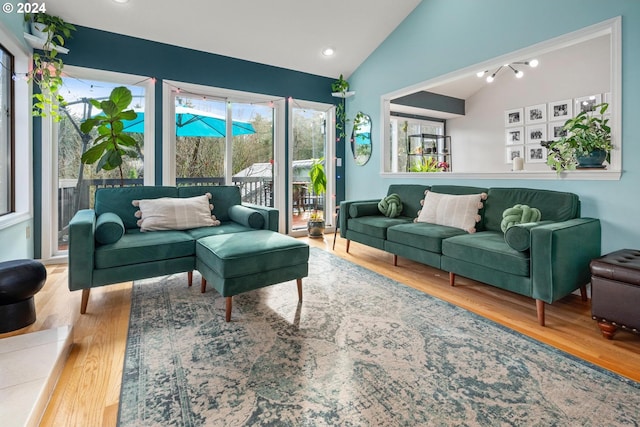 living room with light hardwood / wood-style flooring and vaulted ceiling