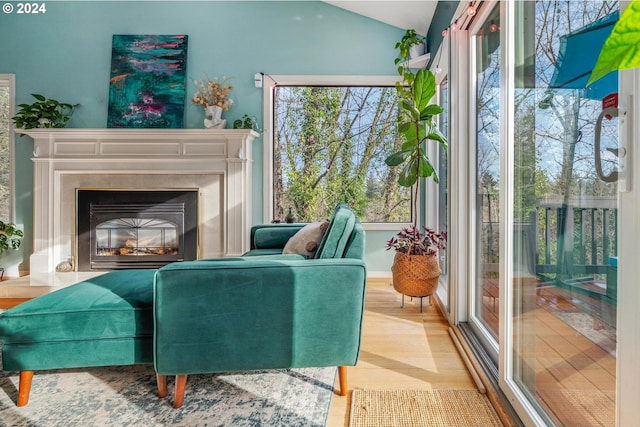 living area with a fireplace, hardwood / wood-style floors, and lofted ceiling