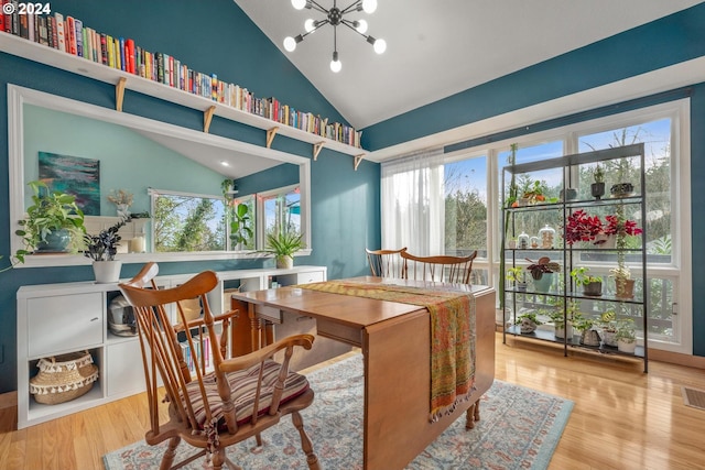 living area with an inviting chandelier, vaulted ceiling, and light wood-type flooring