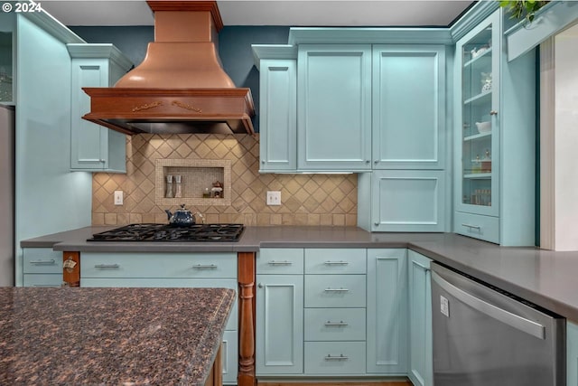 kitchen featuring premium range hood, backsplash, dark stone counters, and stainless steel appliances