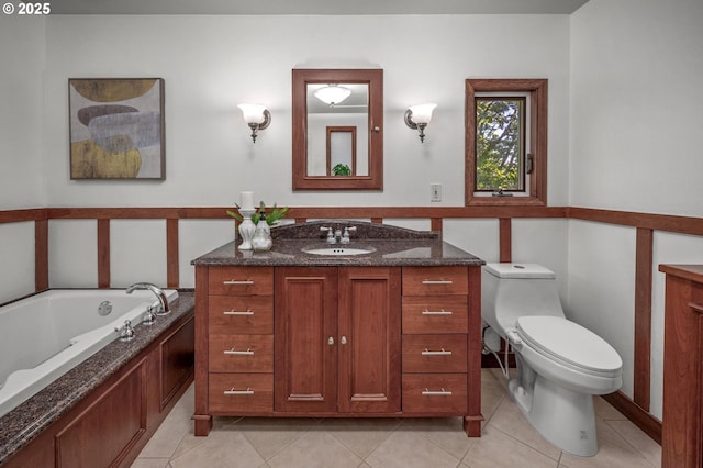 bathroom with vanity, tile patterned flooring, a bath, and toilet