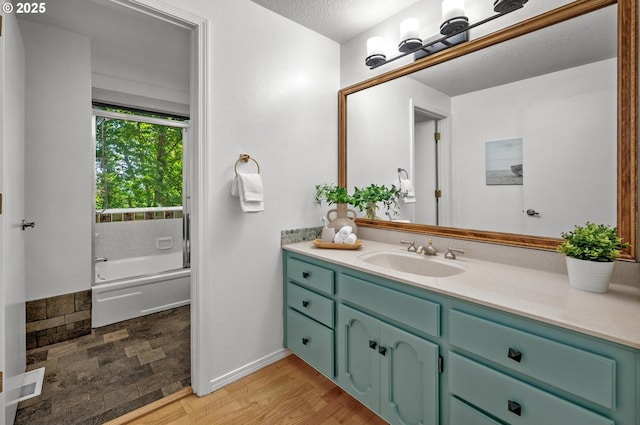 bathroom featuring visible vents, wood finished floors, vanity, baseboards, and  shower combination