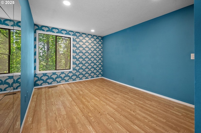 spare room featuring recessed lighting, baseboards, visible vents, and wood finished floors