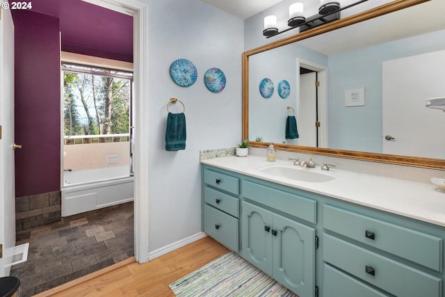 bathroom featuring a bathing tub, hardwood / wood-style floors, and vanity