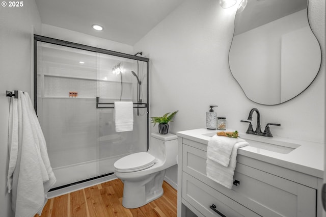 full bath with a shower stall, wood finished floors, vanity, toilet, and recessed lighting