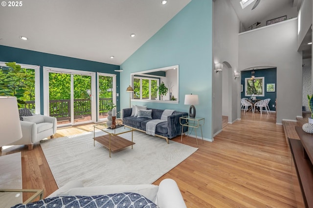 living area featuring recessed lighting, arched walkways, high vaulted ceiling, and wood finished floors