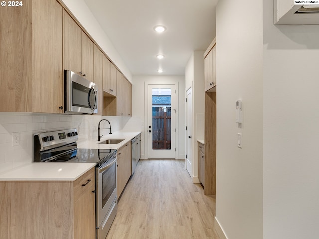 kitchen featuring sink, light wood-type flooring, light brown cabinets, stainless steel appliances, and backsplash