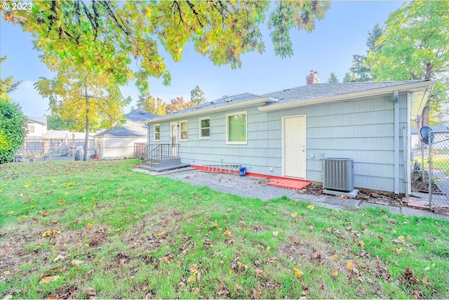 back of house with a yard and central AC