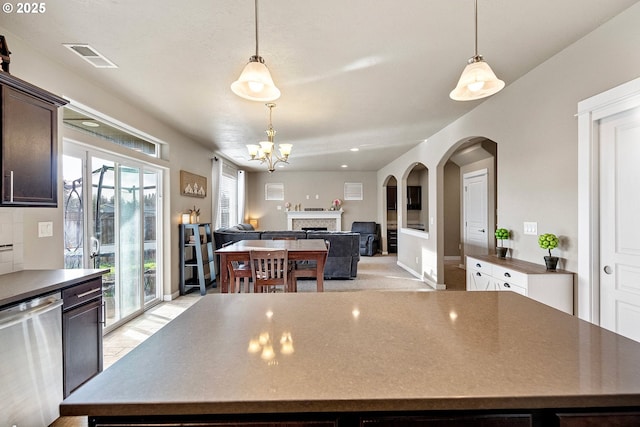 kitchen featuring hanging light fixtures, dishwasher, a center island, and dark brown cabinets